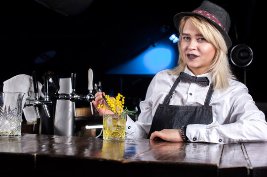 Girl bartender makes a cocktail at the public house