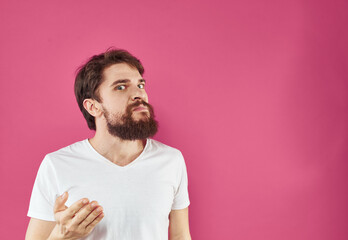 A man on a pink background gestures with his hands Copy Space irritability emotions