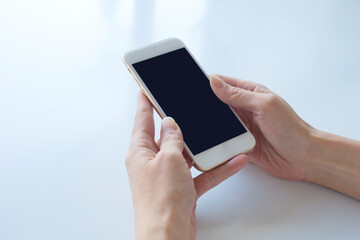 スマートフォンを持つ女性の手　白背景