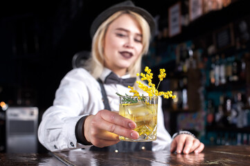 Girl barman makes a cocktail on the alehouse