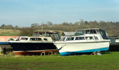Fototapeta na wymiar Old obsolete river boats in a field