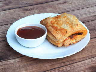 Stuffed vegetable puff, famous Indian Bakery snack, served with Tomato Ketchup, selective focus