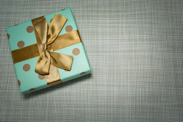 Gift wrapped in celadon paper and gold ribbon