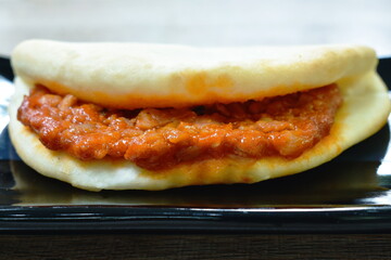 tortilla roll stuffed chop chicken meat with spicy sauce on plate