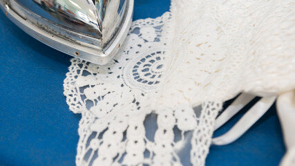Ironing delicate wedding dress on a blue board
