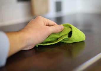 cleaning the kitchen with a green cloth