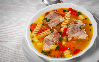 soup with meat, pasta and vegetables in bowl
