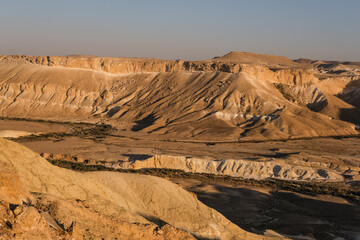 Fototapeta na wymiar View of Nahal Zin at sunset hours, a 120 km long intermittent stream, the largest canyon in country, as seen from Sde Boker field school, Negev desert, Southern Israel, Israel.