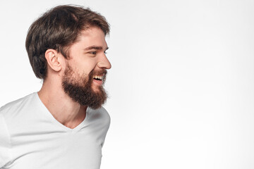 cheerful emotional bearded man gesturing with his hands close-up light background