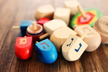 Banner of jewish holiday Hanukkah with wooden dreidels (spinning top) over wooden background