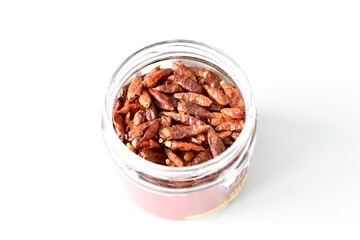 glass jar full of red hot chilli peppers view from top with white background