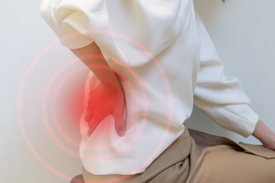 腰痛　腰に手をあてる女性