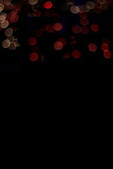 The Black abstract background blurred shimmering multicolor festive lights and space for text. This wallpaper design is good for presentation, websites, greeting cards to set the mood for festivity & 