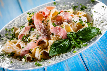 Pasta carbonara on white plate on wooden table
