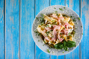 Pasta carbonara on white plate on wooden table
