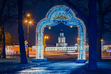 Saint Petersburg winter. Russia on Christmas Eve. Kuntskamera tower in Saint Petersburg. Christmas arch on background of Petersburg. Glowing decorations in Russian cities. New Year holidays in Russia