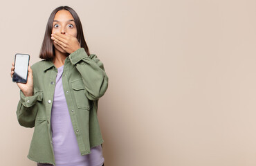 young woman covering mouth with hands with a shocked, surprised expression, keeping a secret or saying oops