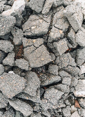 Texture, the background of the destroyed, cracked in pieces of gray asphalt.