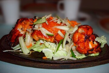 Roasted chicken slices served with vegetables in a sizzling plate