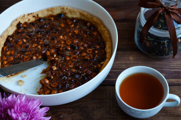 slice of homemade nut tart on a white plate on a dark wooden background