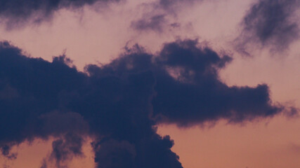 Silhouettes de cumulus dans un ciel teinté de mauve 