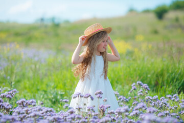 little girl in a straw hat in a field of purple flowers rejoice	