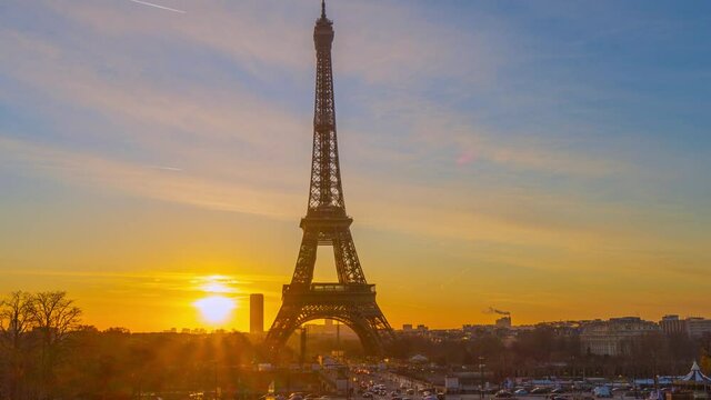 4K timelapse of Paris at sunrise with the Eiffel Tower at the Trocadero gardens and the traffic,the most famous landmark in Paris,France.Golden hour in an autumn winter sunny day in 