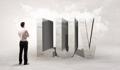 Rear view of a businessman standing in front of LUV abbreviation, attention making concept