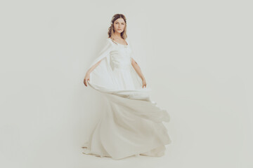 Fototapeta na wymiar Perfect woman in white silky evening gown on white background