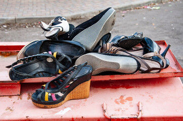 Worn Shoes. Many worn-out shoes discarded in the streets. High quality photo