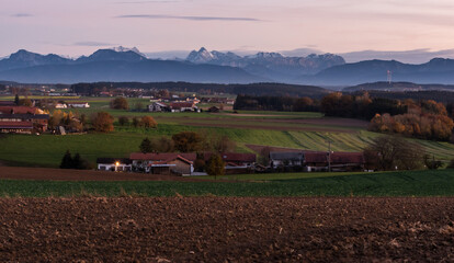 Blick auf die Alpen im Chiemgau am Abend mit Felder n und Häusern