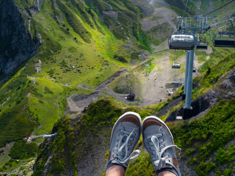 Mountain resort in summer, sneakers on the background of a mountain landscape, first-person photo.