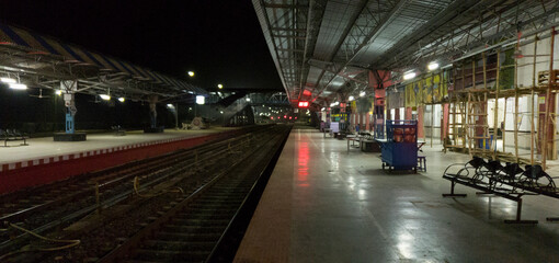 Empty railway platform at night with no people around.