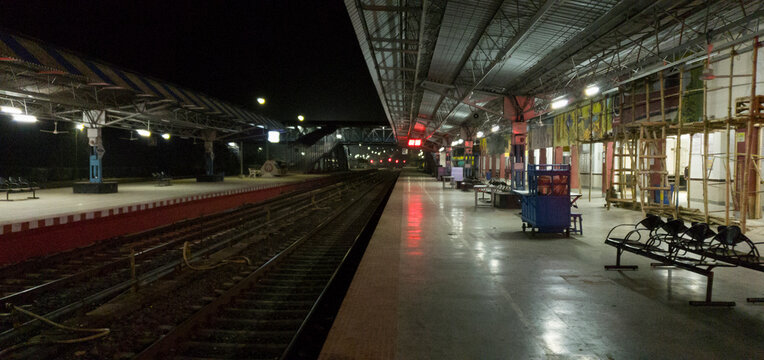 Empty railway platform at night with no people around.