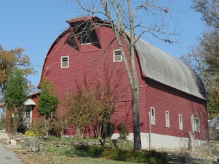 Roadside shot of a big red barn built close to the road at Eureka Springs, Arkansas.