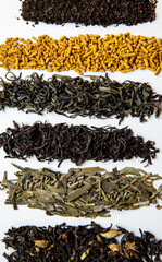 Various types of tea scattered on a light background. Assorted tea. Vertical image