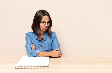 young woman feeling sad, upset or angry and looking to the side with a negative attitude, frowning...