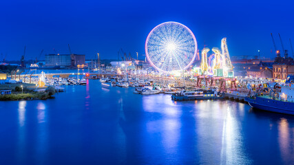 Ships, cranes called Dzwigozaury and amusement park at Odra River Boulevards in Szczecin. Crowds enjoying Days of the Sea. Long exposure night photo © Dawid