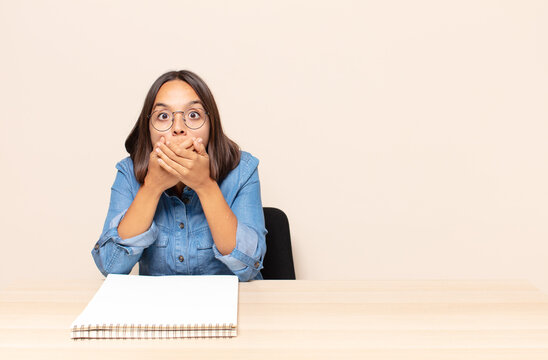 young woman covering mouth with hands with a shocked, surprised expression, keeping a secret or saying oops