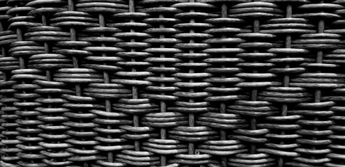 Pattern of dark grey or gray weave bamboo background. Art of Natural  material and wallpaper. Selective focus.