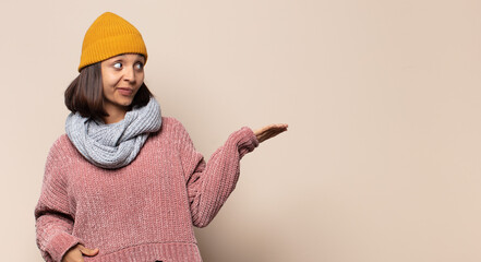 young woman thinking, feeling doubtful and confused, with different options, wondering which...