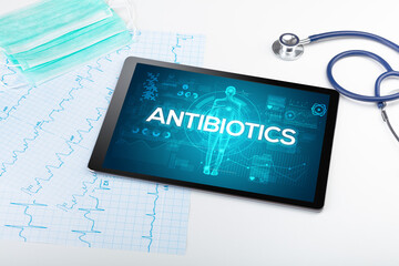 Tablet pc and doctor tools with ANTIBIOTICS inscription, coronavirus concept