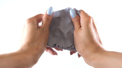 Fototapeta premium Female hands are molded from silver gray blue plasticine, developing activities for children.