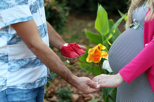 Newborn baby shoes with pregnan woman and father
