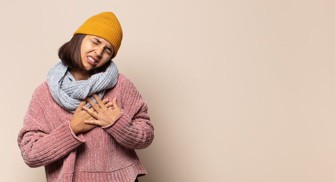young woman covering mouth with hands with a shocked, surprised expression, keeping a secret or saying oops