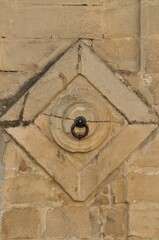 Detalle decorativo geométrico en una fachada para una argolla de atar caballos
