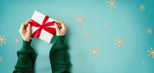 Person making a Christmas gift box - overhead view