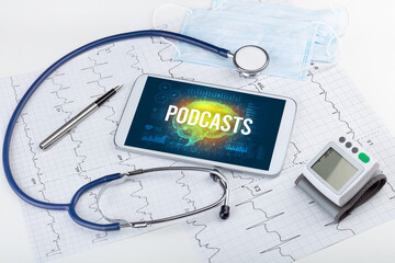 Tablet pc and medical tools with PODCASTS inscription, social distancing concept