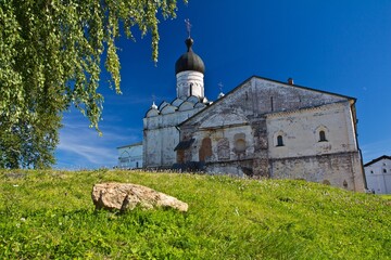 The view on the green lawn in front of the white stone medieval Ferapontov convent in Vologda region, Russia.