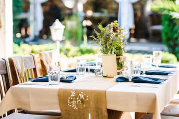 Outdoor wedding table decoration with fresh flowers and blank table cards. Special event table set up. Boho wedding decoration.